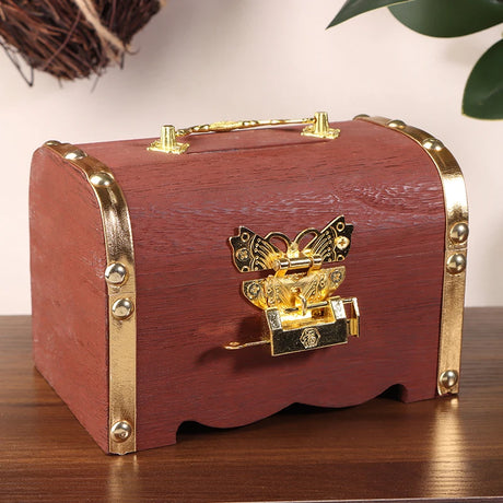 Wooden box with gold accents and a butterfly lock on a wooden surface.