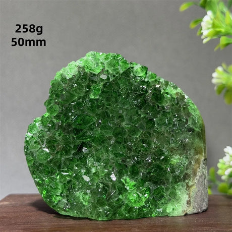 Green crystal rock on a wooden surface with a gray background