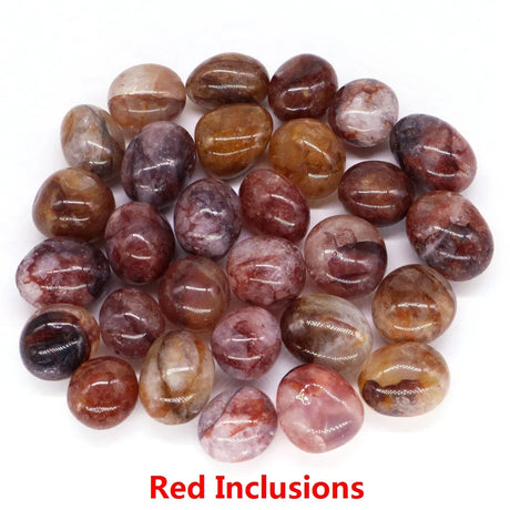Polished gemstones with red inclusions on a white background