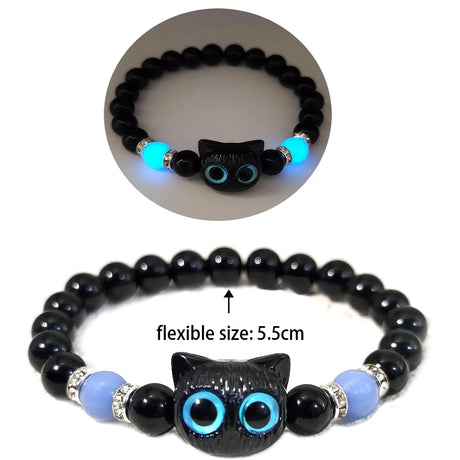 Black beaded bracelet with cat-shaped ends and glowing blue eyes on a white background.