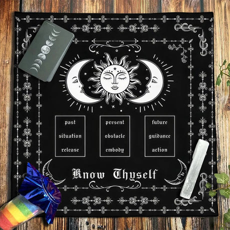 Black cloth with celestial design and text on a wooden surface