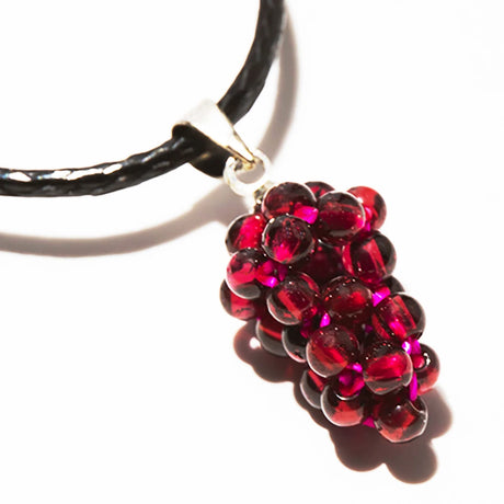 Necklace with a red grape cluster pendant on a white background