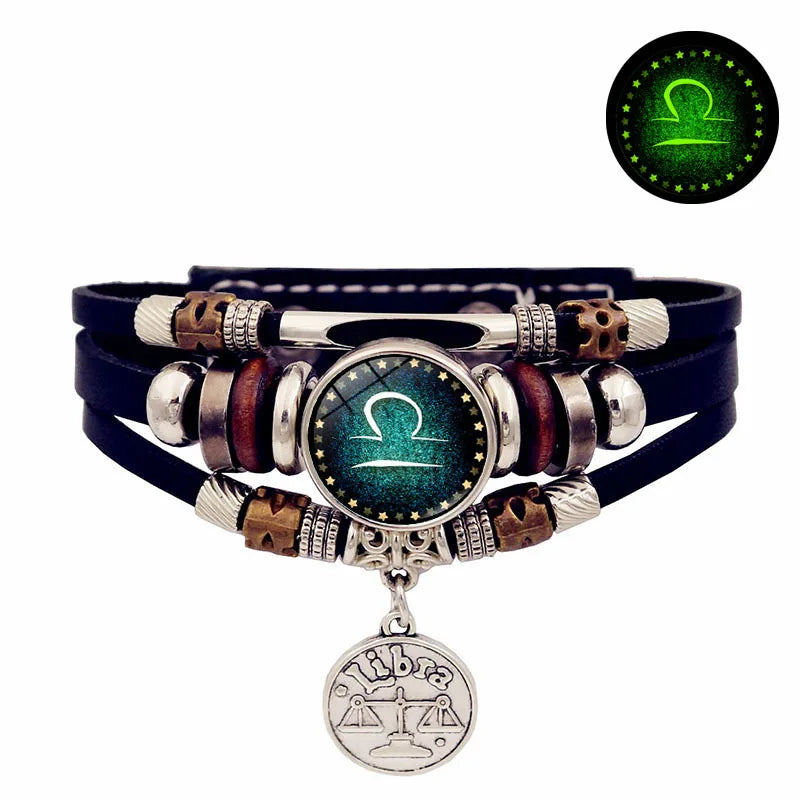 Multicolored beaded bracelet with a central green gemstone and pendant on a white background