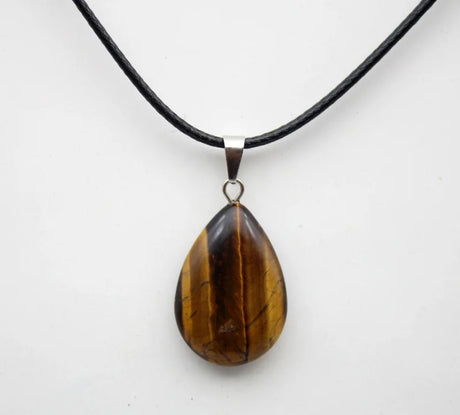 Teardrop-shaped tiger's eye pendant on a black cord against a white background