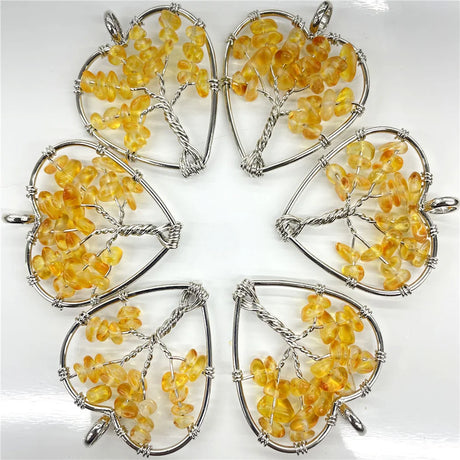 Five heart-shaped amber pendants with silver wire wrapping on a white background