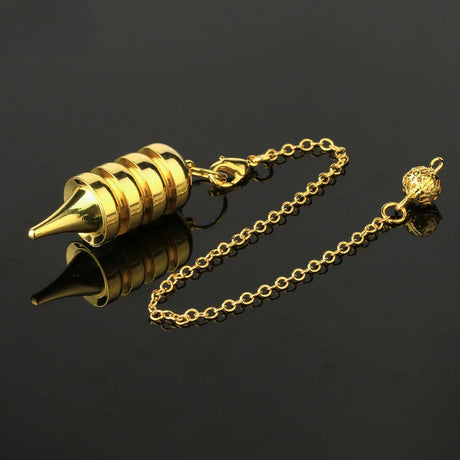 Gold-colored pen nib with chain on a black background