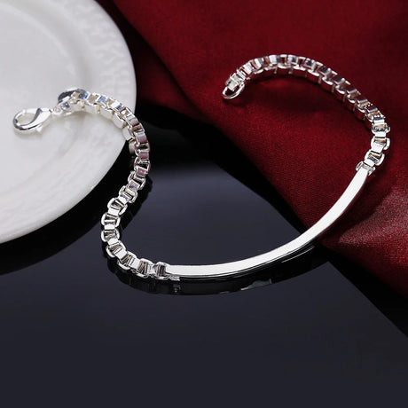 Silver bracelet with clear stones on a dark surface