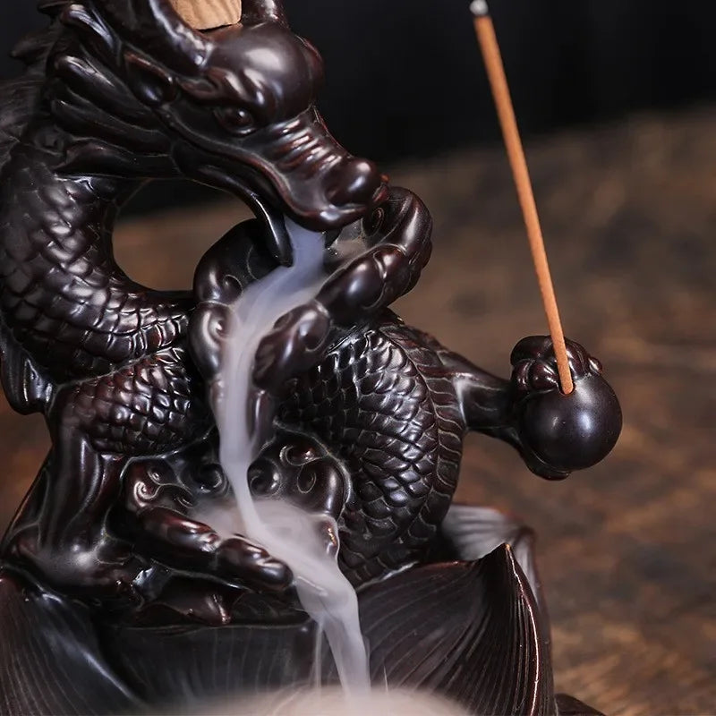 Dragon-shaped incense burner with incense stick and smoke on a wooden surface