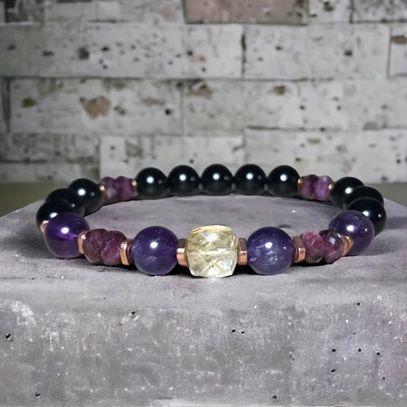 Multicolored beaded bracelet on a textured surface with a stone wall background