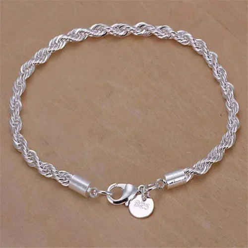 Silver rope chain bracelet with a heart charm on a beige background