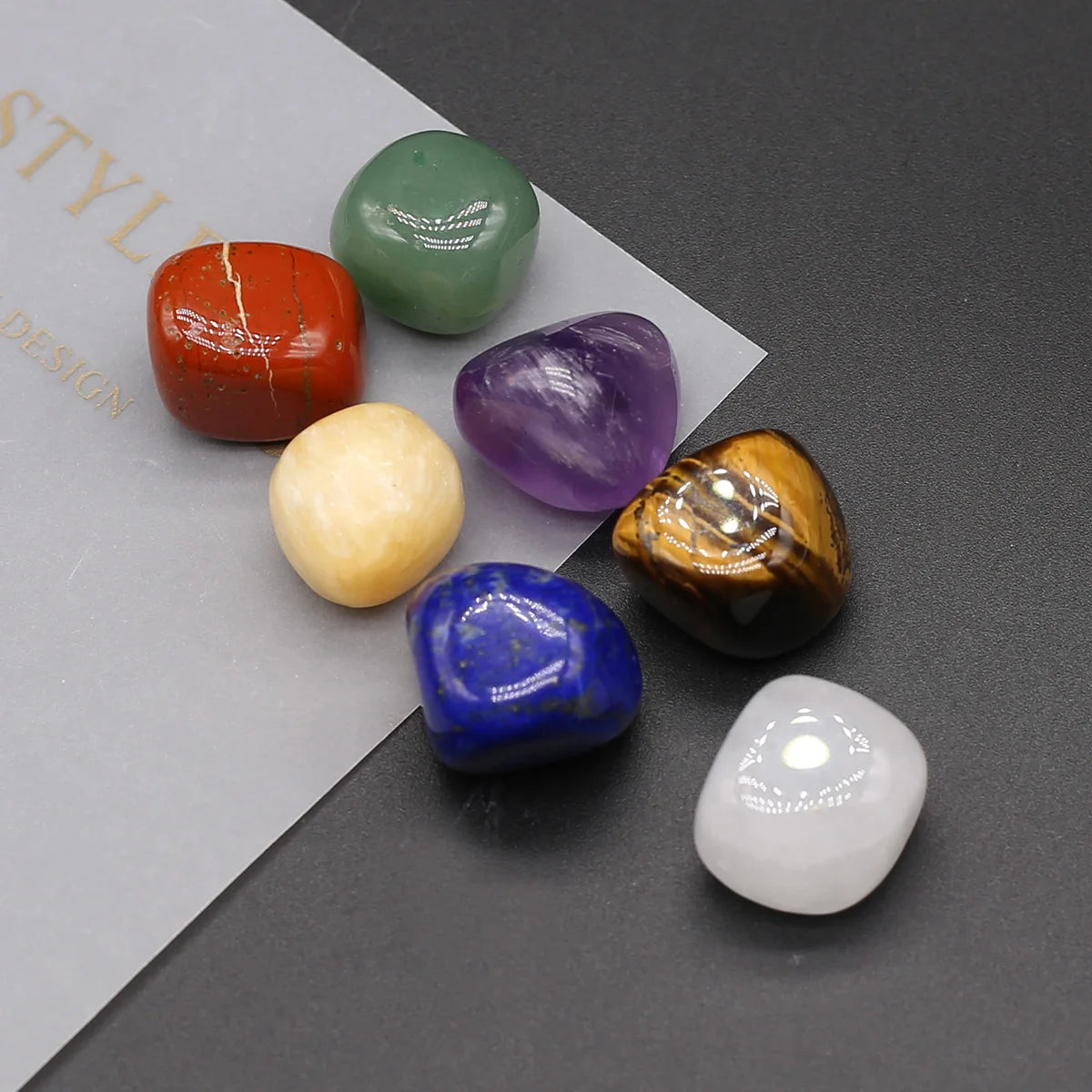 Set of colorful crystals on a gray surface with a white paper background