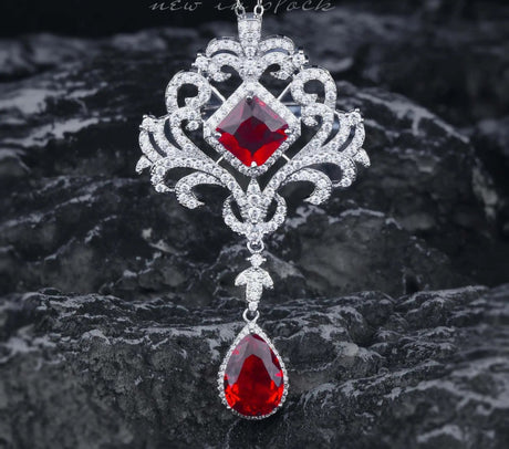 Elegant necklace with red gemstones on a dark textured background, featuring the brand 'ZhenRong'.
