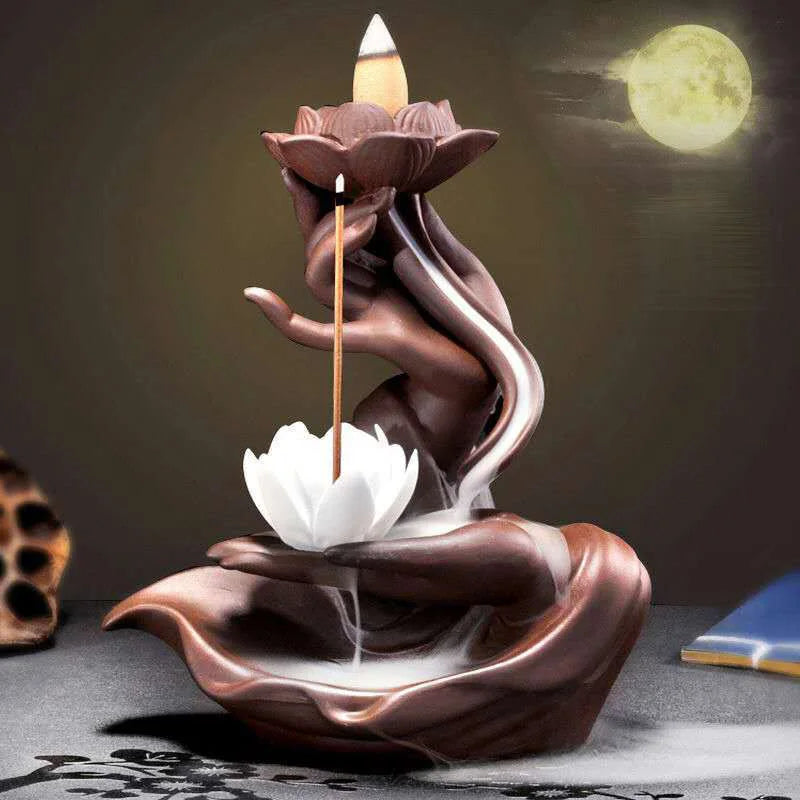Ceramic incense burner shaped like a lotus flower with a candle on a dark background.