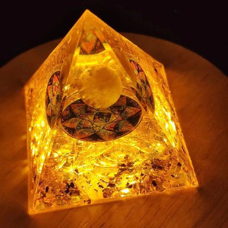 Decorative crystal pyramid with LED lights on a wooden surface