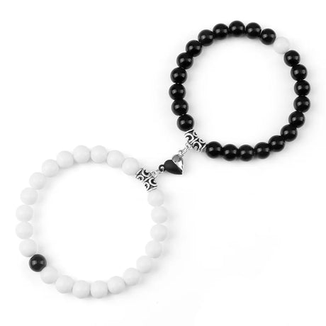 Two beaded bracelets, one with black beads and the other with white beads, on a white background.