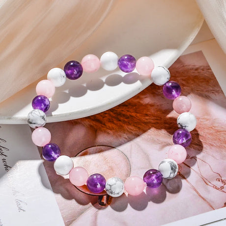 Multicolored beaded bracelet on a white surface with a blurred background