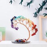 Colorful crystal tree on a white surface with a blurred background
