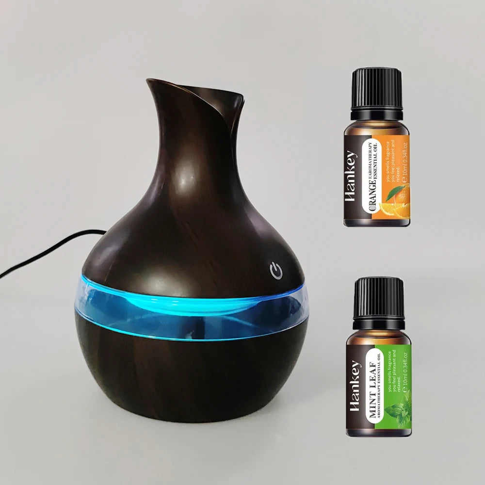 Black essential oil diffuser with two Hankey essential oil bottles on a light gray background