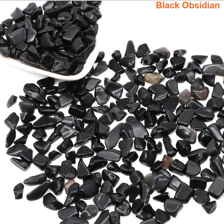 Black obsidian stones with a white scoop on a white background