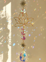 Decorative hanging ornament with gold lotus design and colorful crystals on a beige background