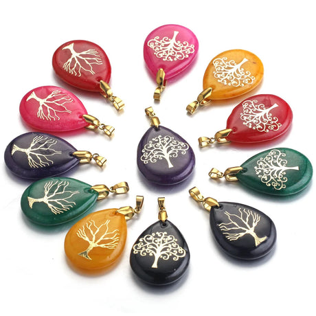 Set of colorful stone pendants with tree designs on a white background