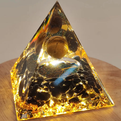 Triangular pyramid with embedded stones on a wooden surface
