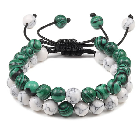 Stack of green and white beaded bracelets on a white background