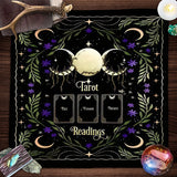 Decorative mat with tarot design on a wooden surface with tarot cards and crystals.