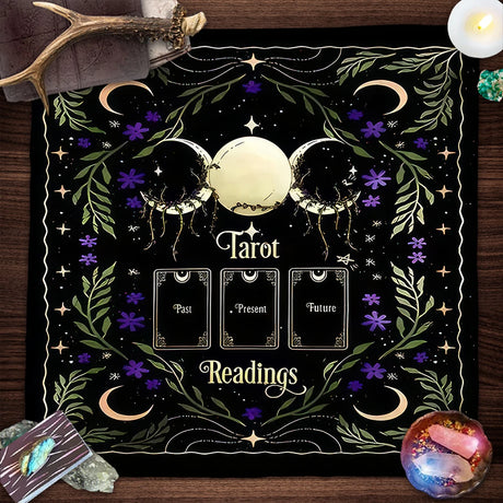 Decorative mat with tarot design on a wooden surface with tarot cards and crystals.