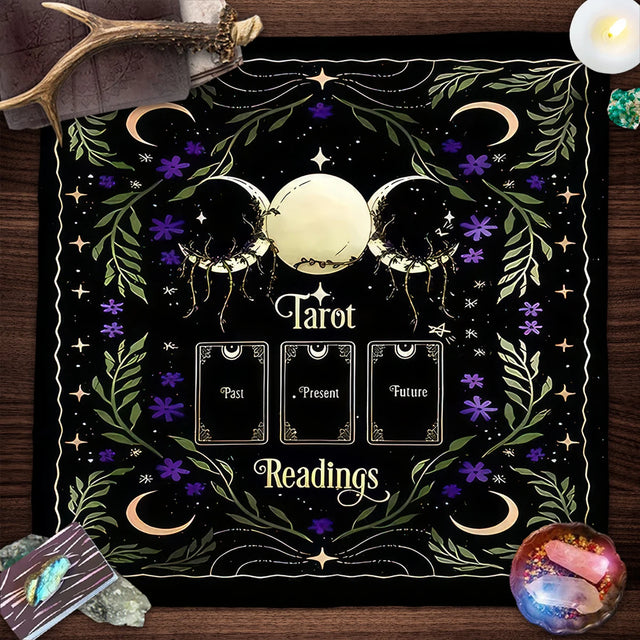 Decorative mat with tarot design on a wooden surface with tarot cards and crystals.