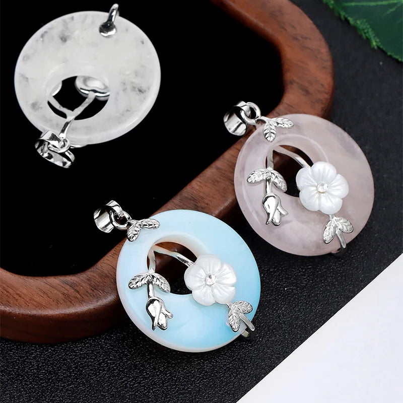 Three round pendants with floral designs on a dark surface