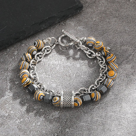 Bracelet with yellow and black patterned beads on a gray surface
