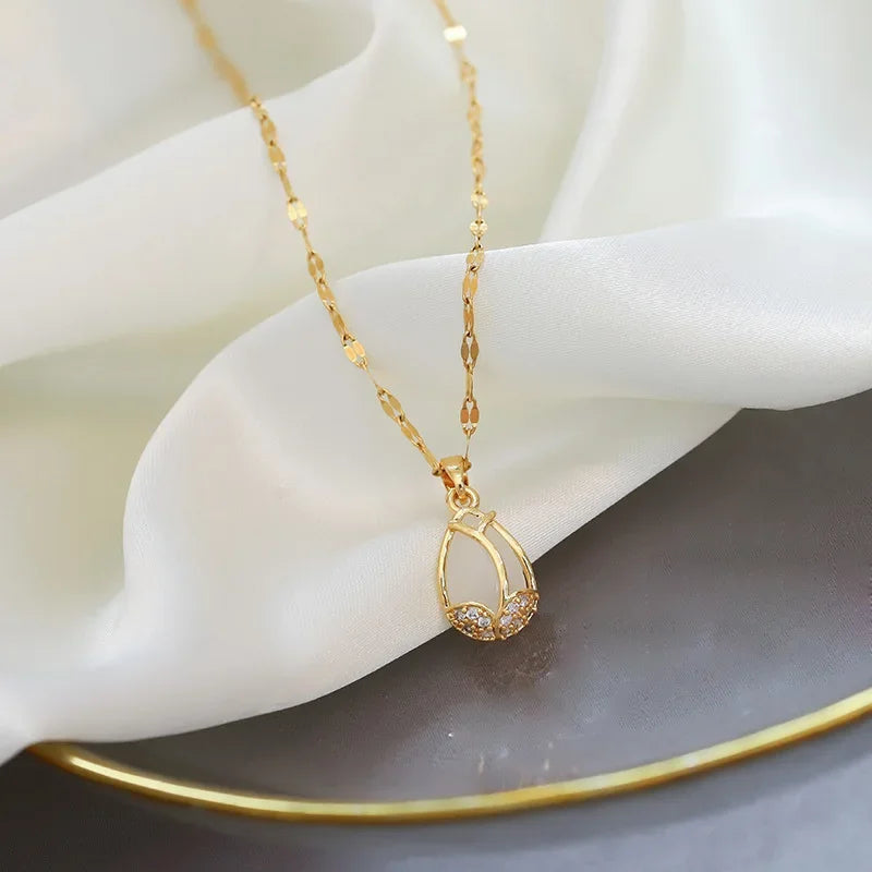 Gold necklace with a delicate pendant on a white surface