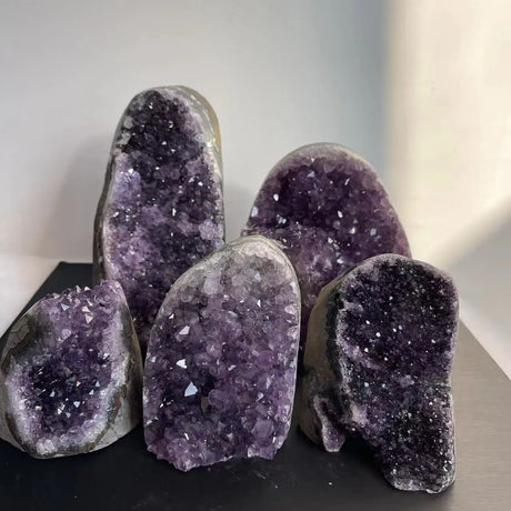 Amethyst geode crystals on a dark surface with a blurred background