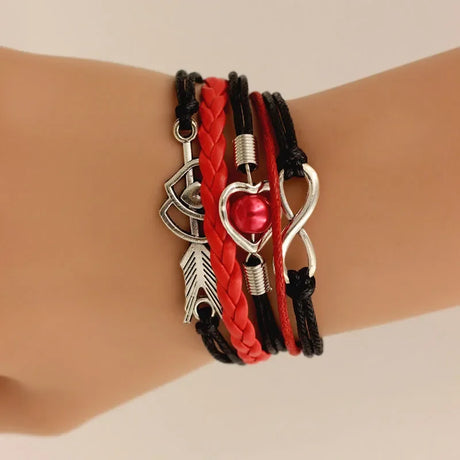 Multistrand bracelet with heart, arrow, and infinity symbols on a wrist against a neutral background