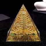 Pyramid-shaped object with gold and green elements on a black background