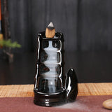 Black ceramic incense burner with smoke on a dark background