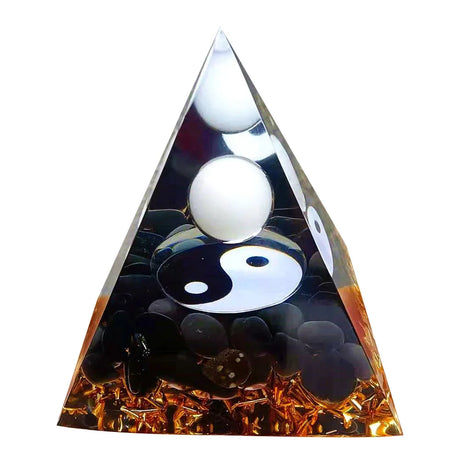 Triangular crystal with yin yang symbol and white balls inside on a white background