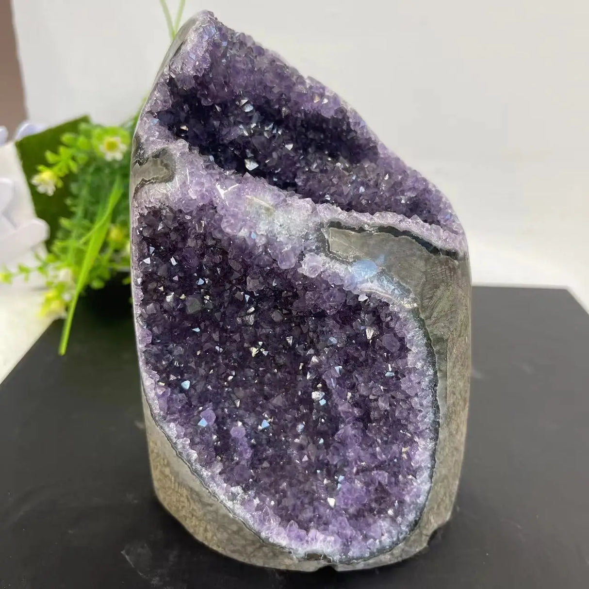 Amethyst geode on a black surface with a blurred background