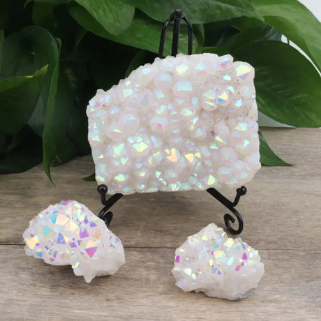Iridescent crystal rock set on a wooden surface with green leaves in the background