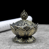Decorative bronze incense burner on a gray surface with a black background