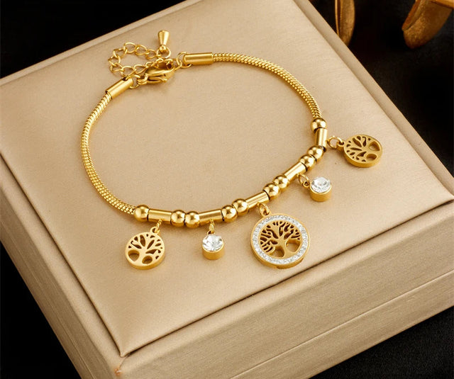Gold bracelet with tree-shaped charms on a beige box, featuring the brand 'DIEYURO'.