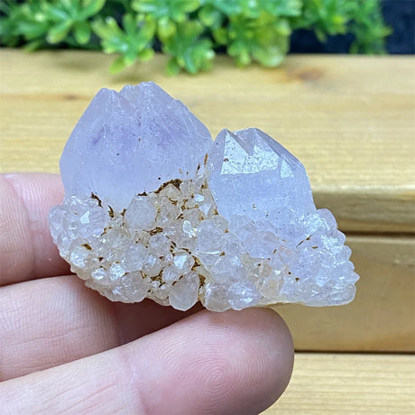 Crystal rock held in a hand with a natural background