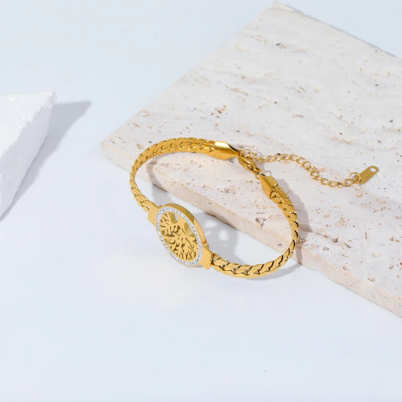 Gold bracelet on a light wooden surface