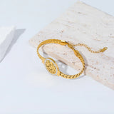 Gold bracelet on a light wooden surface