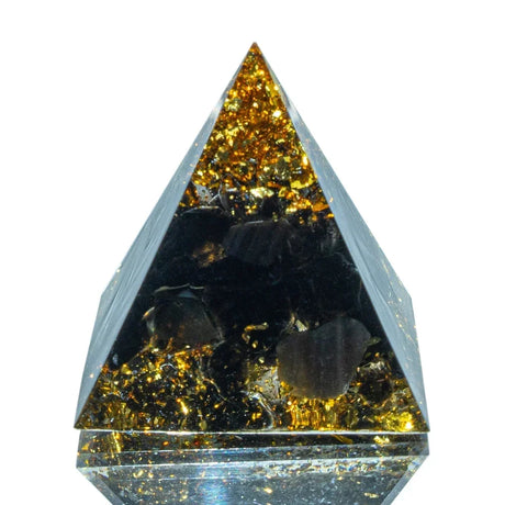 Pyramid-shaped crystal with embedded stones on a white background