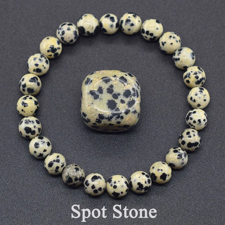 Bracelet made of dalmatian jasper beads with a matching stone on a dark background.