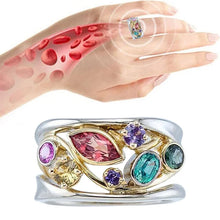 Multicolored gemstone ring on a hand with a close-up of skin texture.