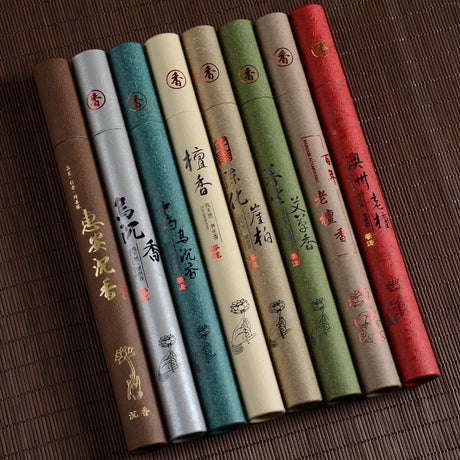 Set of incense sticks in various colored packaging with text and designs on a textured surface.