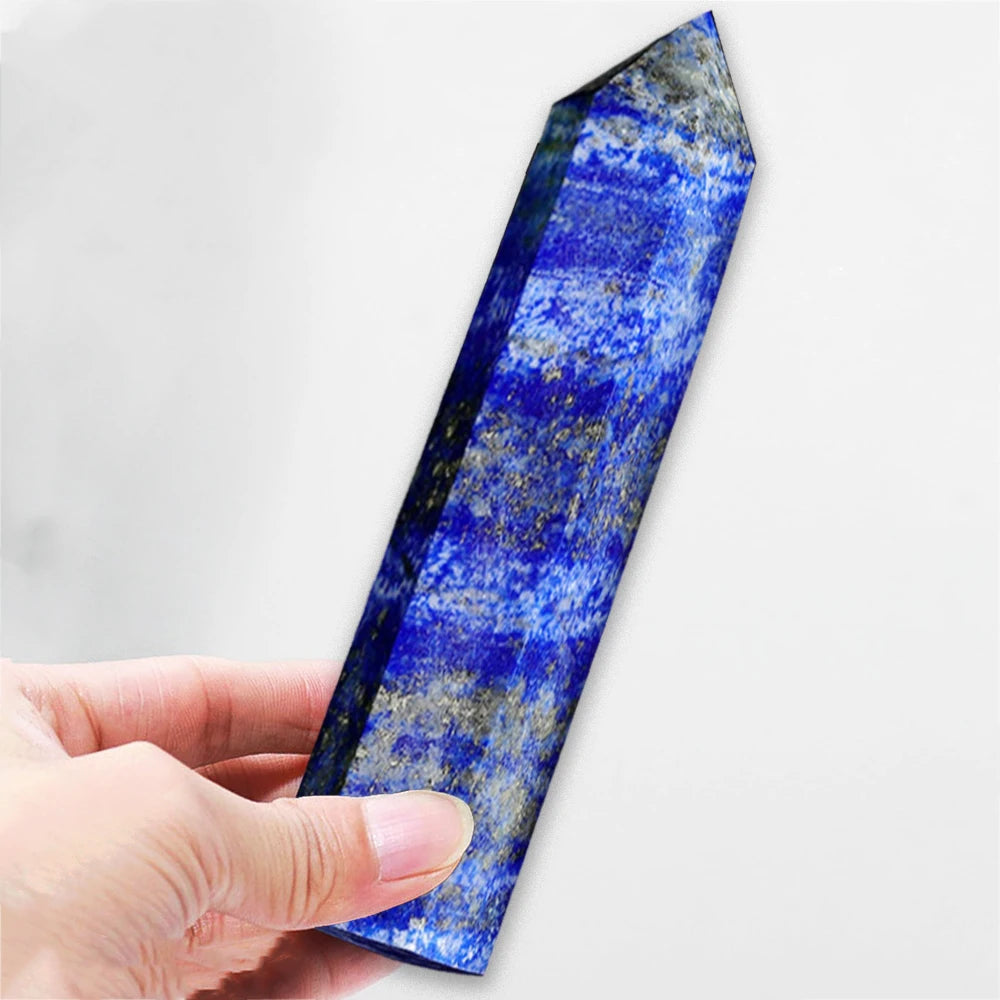 Hand holding a blue crystal against a white background
